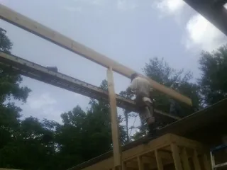 Carpenter setting a ridge beam over a new addition frame — Ice Dam Removal by Roofing Brothers in La Center